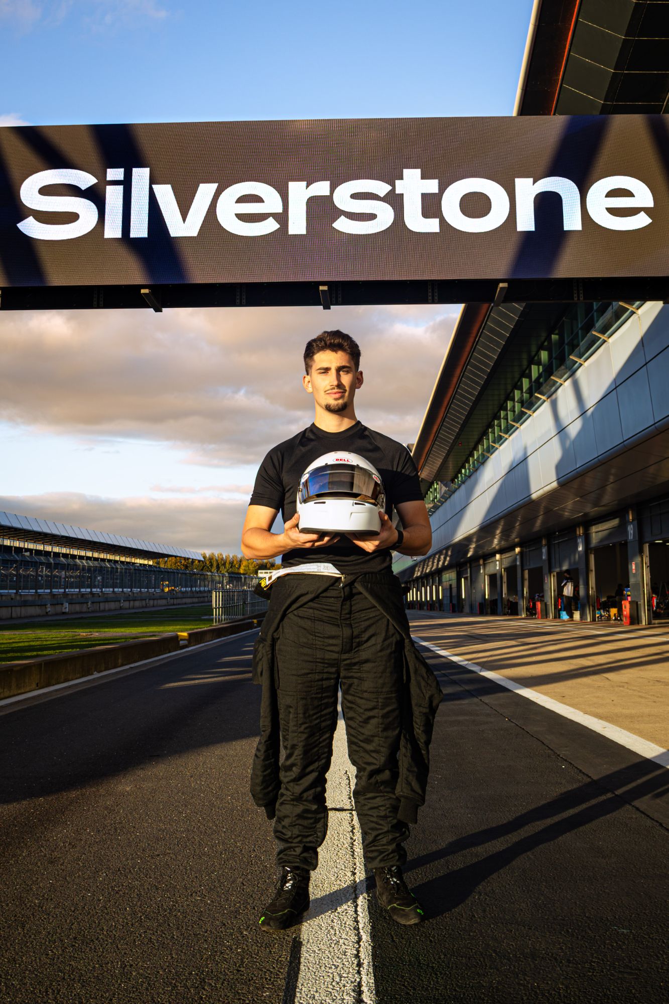 Christian Valverde holding his helmet in the Silverstone pit lane