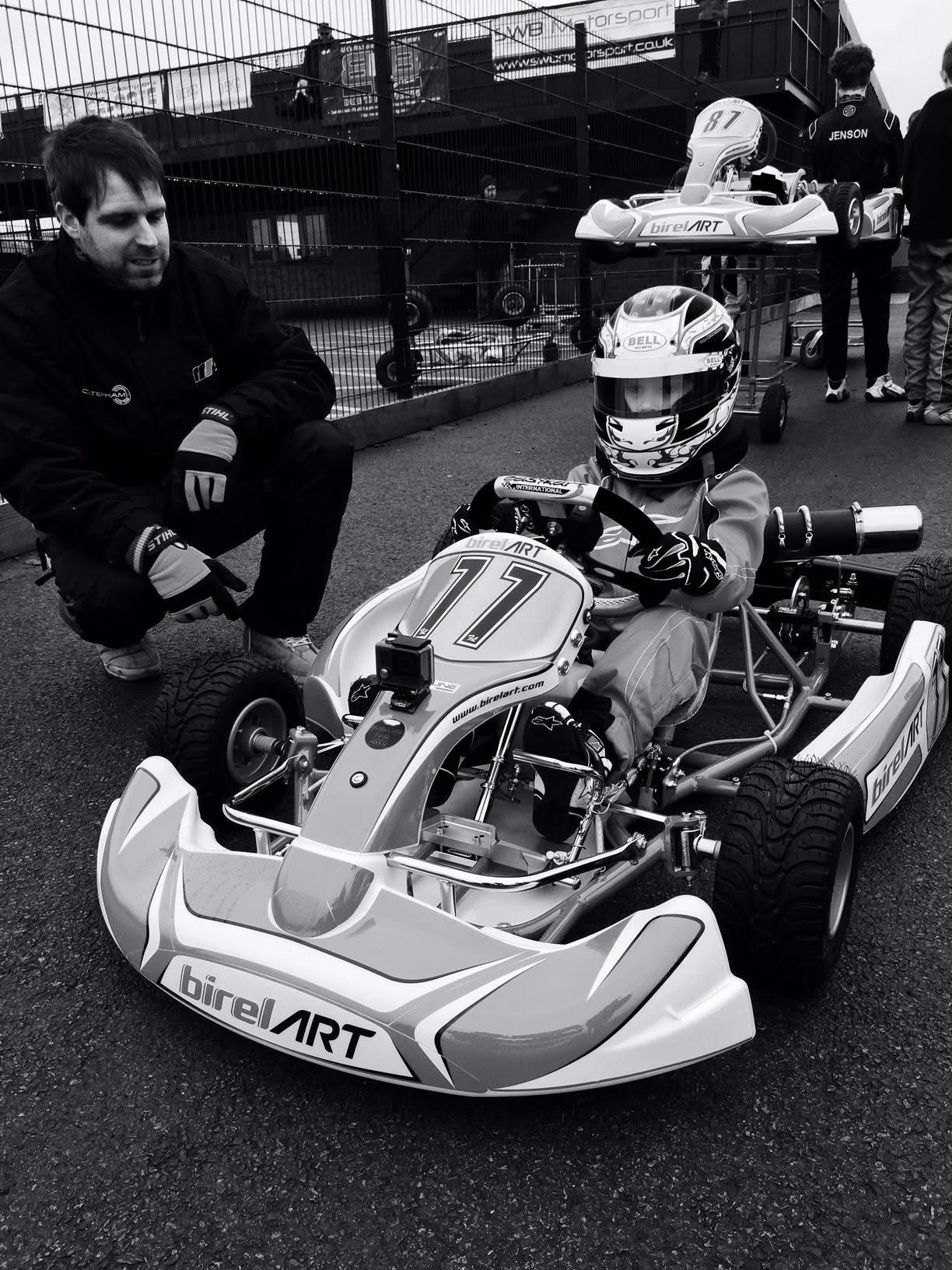 Christian Valverde as a young boy in a kart, with a mechanic beside him
