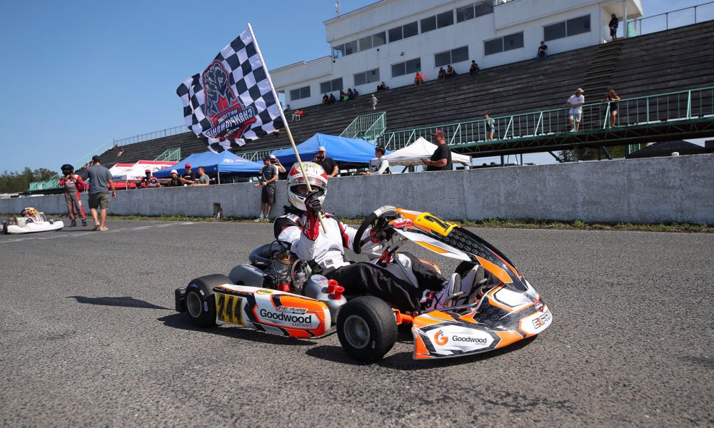 Christian Valverde celebrating a karting win with the chequered flag